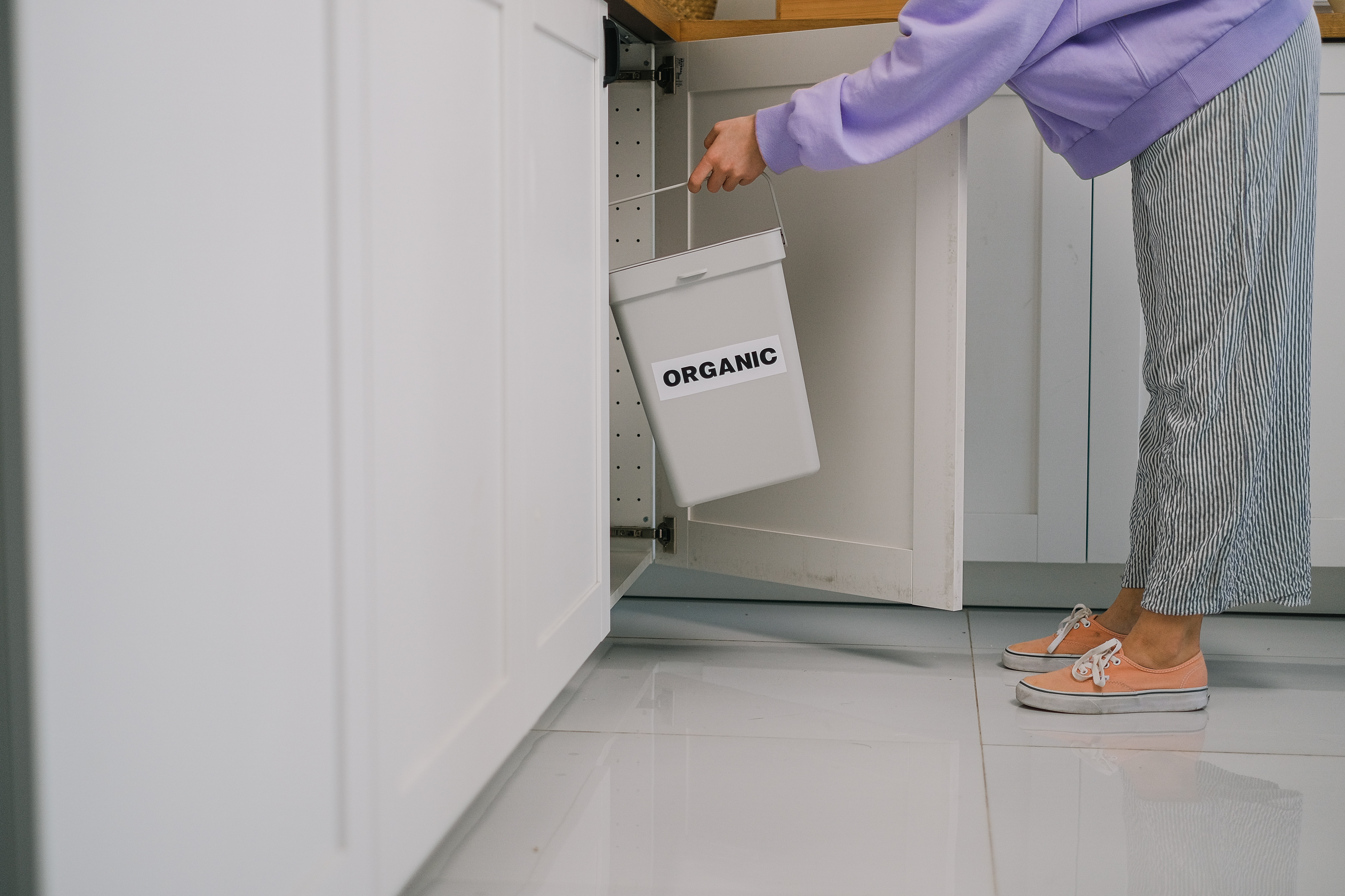 Man placing plastic bottle in recycle bin in office
